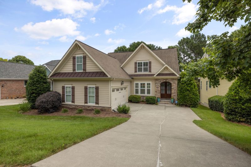 Suburban family home with a manicured lawn and a paved driveway.